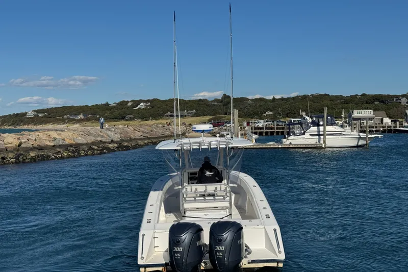 Slide: The Image of 2003 Venture 34 Open boat with twin Yamaha engines in a scenic harbor. - 7