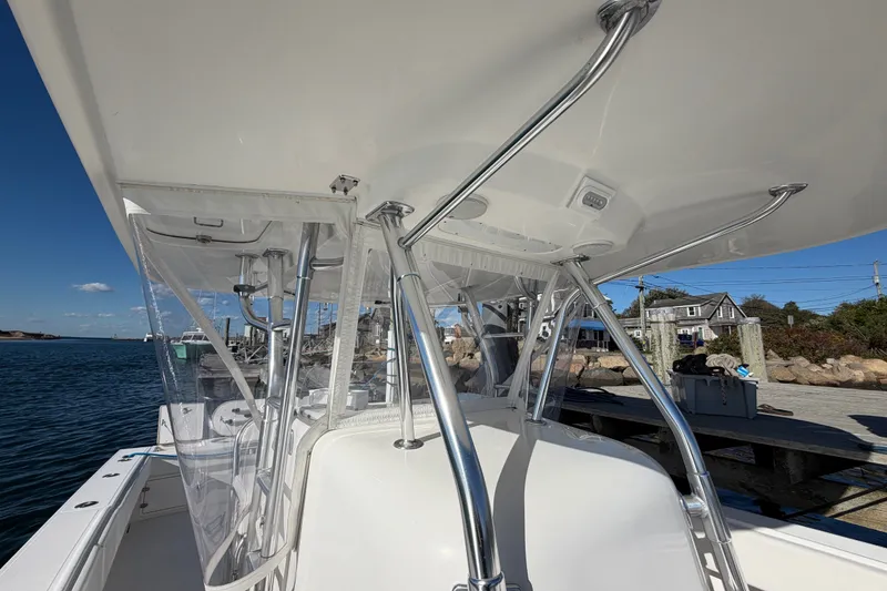 Slide: The Image of 2003 Venture 34 Open boat with T-top and clear enclosures docked by the water. - 8
