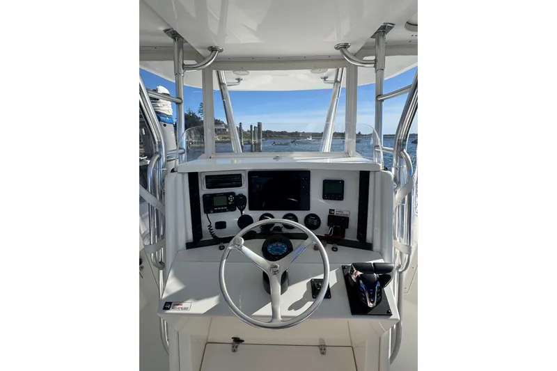 Slide: The Image of 2003 Venture 34 Open boat helm with steering wheel and navigation equipment, overlooking water. - 10