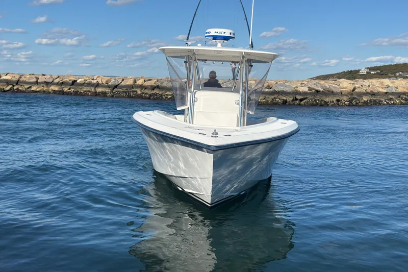 Slide: The Image of 2003 Venture 34 Open boat on calm water, clear sky, rocky shoreline in background. - 4
