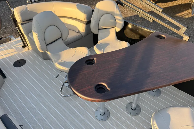 Slide: The Image of 2019 South Bay 224E boat interior with beige seating and wooden table. - 16