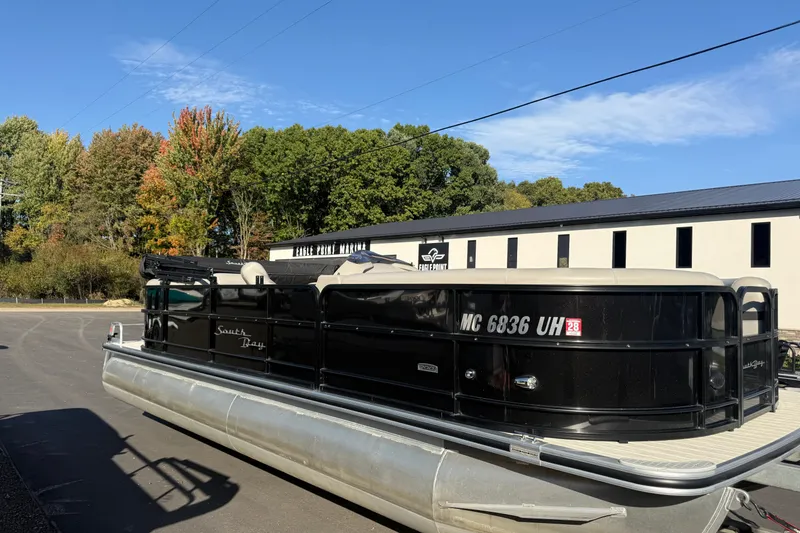 Slide: The Image of 2019 South Bay 224E pontoon boat parked near marina, surrounded by autumn trees. - 6