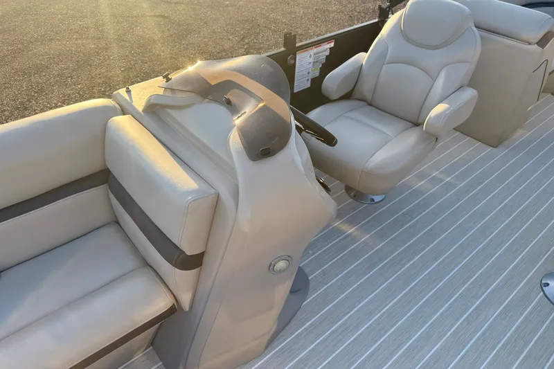 Slide: The Image of 2019 South Bay 224E boat interior with beige seating and steering console. - 20