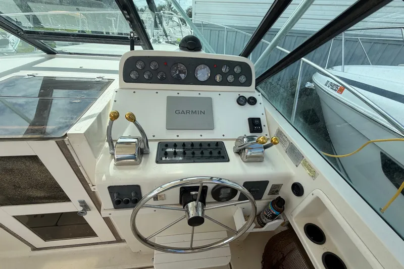 Slide: The Image of 1996 Pursuit 3100 Offshore boat helm with Garmin navigation system and dual throttle controls. - 6