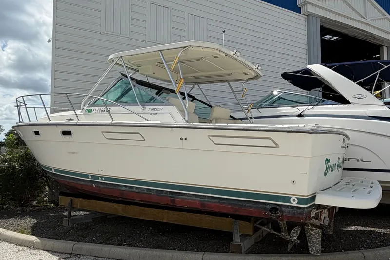 Slide: The Image of A 1996 Pursuit 3100 Offshore boat is on a trailer next to a building. - 4