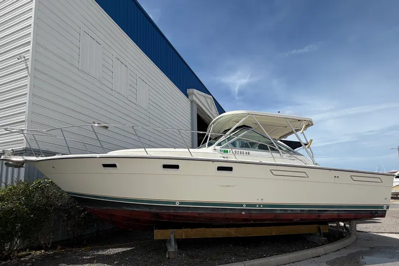 Slide: The Image of A 1996 Pursuit 3100 Offshore boat is on a dry dock in front of a building. - 2