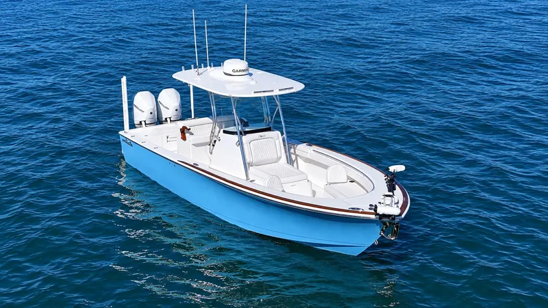 Slide: The Image of A 2025 Valhalla V-29 Hybrid on calm water. It features a blue hull design and a T-top. - 4
