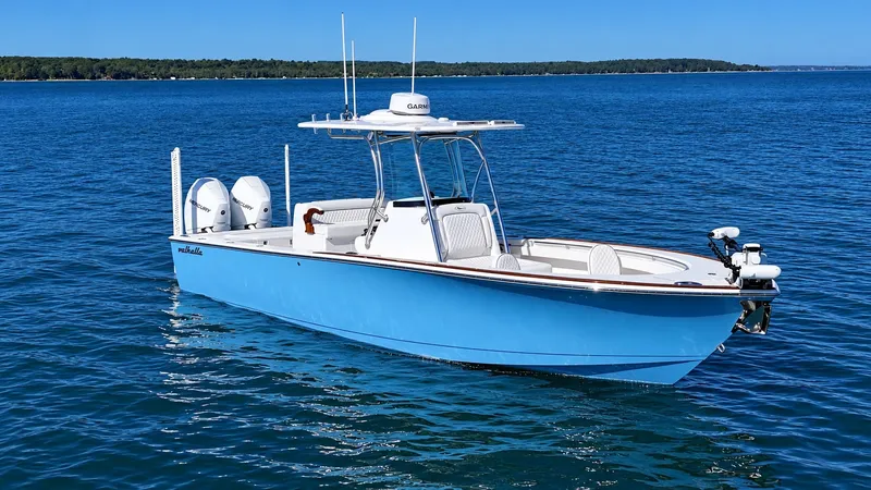 Slide: The Image of A 2025 Valhalla V-29 Hybrid on calm waters. It features a light blue hull design. - 2