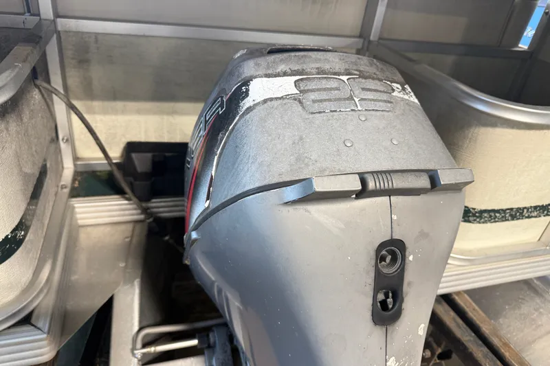 Slide: The Image of 1999 Crest II boat motor, silver with visible wear, in a metal enclosure. - 3