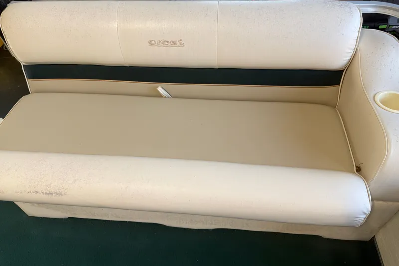 Slide: The Image of 1999 Crest II boat seat with beige upholstery and cup holder. - 6