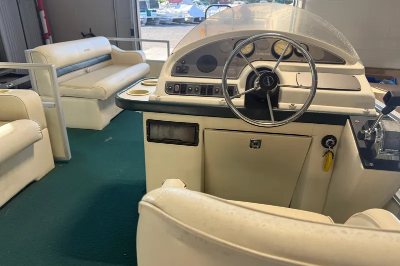 Slide: The Image of 1999 Crest II boat interior with steering wheel, dashboard, and beige seating. - 16
