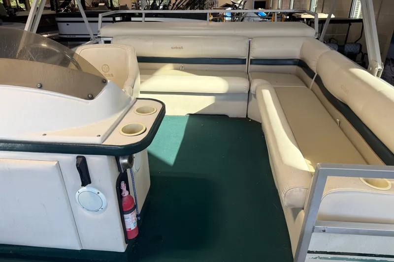 Slide: The Image of 1999 Crest II boat interior with beige seating and green carpet. - 7