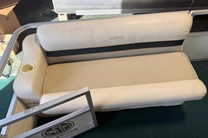 Slide: The Image of 1999 Crest II boat seat with cup holder, beige upholstery, and visible wear. - 8