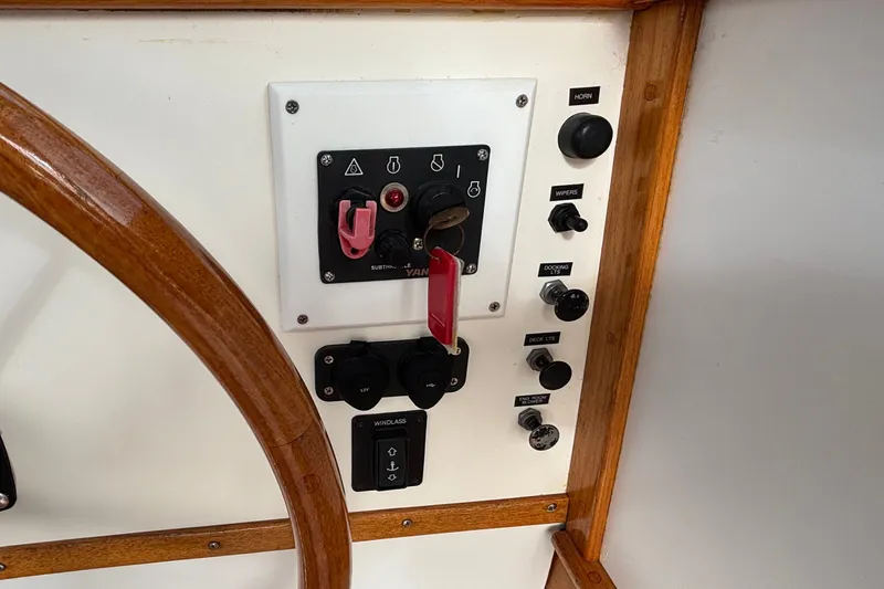 Slide: The Image of Control panel of a 1993 Webbers Cove Pemaquid Beach 26 boat with wooden steering wheel. - 30