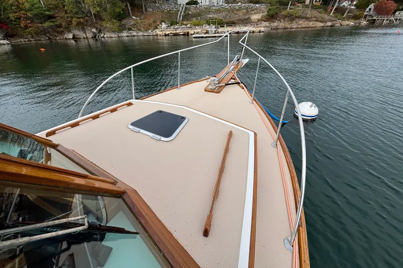 Slide: The Image of 1993 Webbers Cove Pemaquid Beach 26 boat deck on calm water near rocky shoreline. - 34