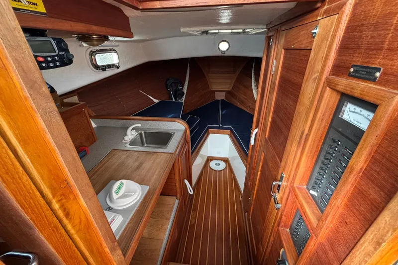 Slide: The Image of Interior of 1993 Webbers Cove Pemaquid Beach 26 boat with wood finish and compact amenities. - 17