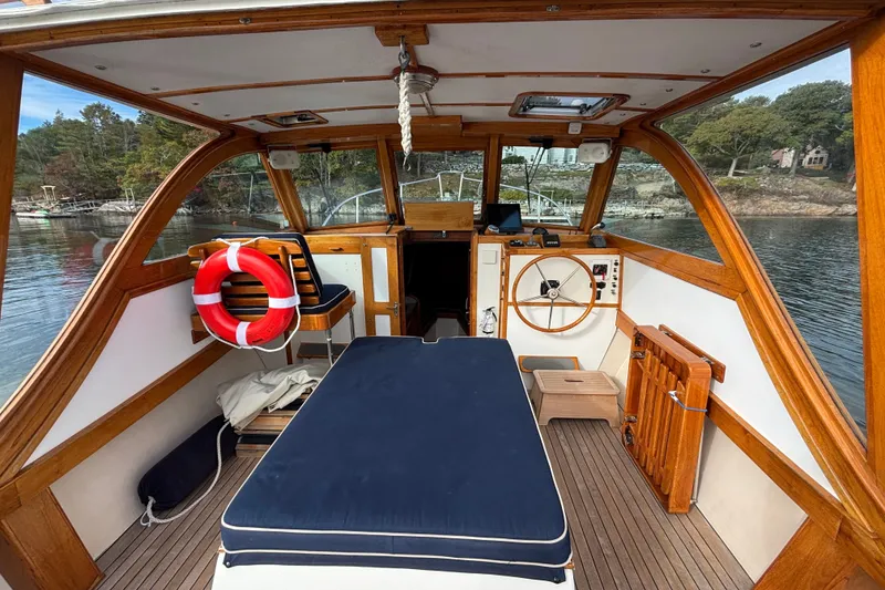 Slide: The Image of 1993 Webbers Cove Pemaquid Beach 26 boat interior with wooden accents and steering wheel. - 12