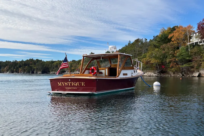 Slide: The Image of Webbers Cove Pemaquid Beach 26 boat, 1993 model, named "Mystique" on calm water with scenic background. - 9