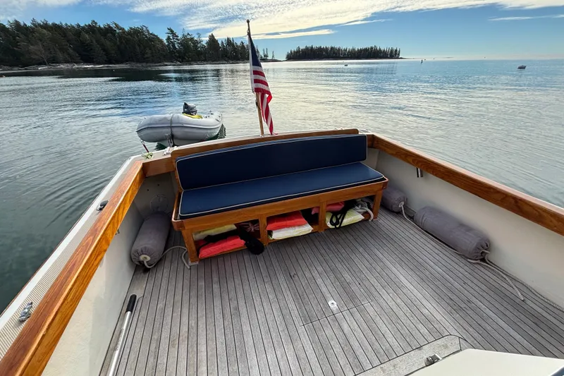 Slide: The Image of 1993 Webbers Cove Pemaquid Beach 26 boat interior with wooden deck and seating, scenic water view. - 10