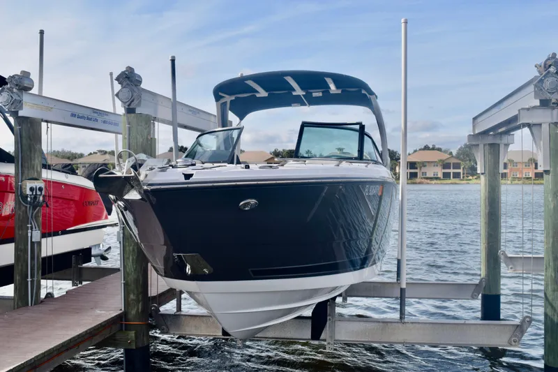 Slide: The Image of 2025 Monterey 275SS Super Sport boat on lift at marina dock. - 1