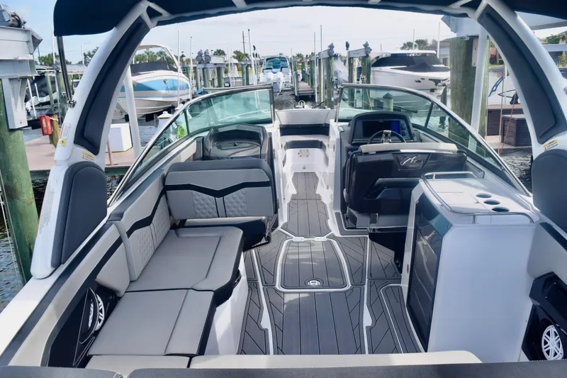Slide: The Image of 2025 Monterey 275SS Super Sport boat interior with sleek seating and modern dashboard at a marina. - 35