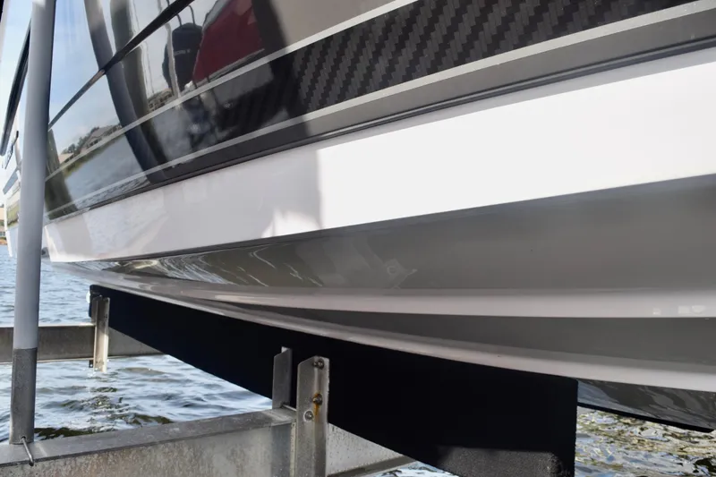 Slide: The Image of 2025 Monterey 275SS Super Sport boat hull on a lift by the water. - 16