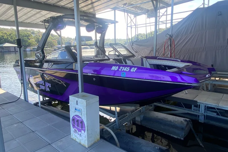 Slide: The Image of 2017 Tigé RZX3 boat in vibrant purple, docked under a covered marina. - 32