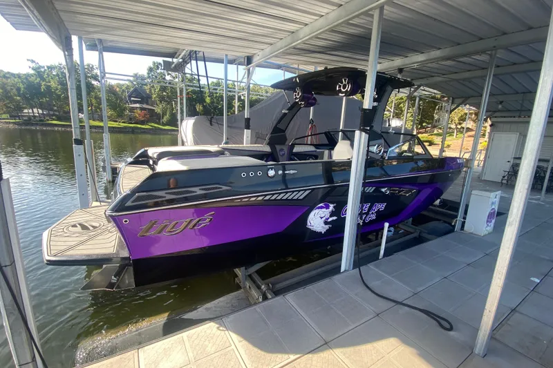 Slide: The Image of 2017 Tigé RZX3 boat in dock, featuring a sleek purple and black design. - 31