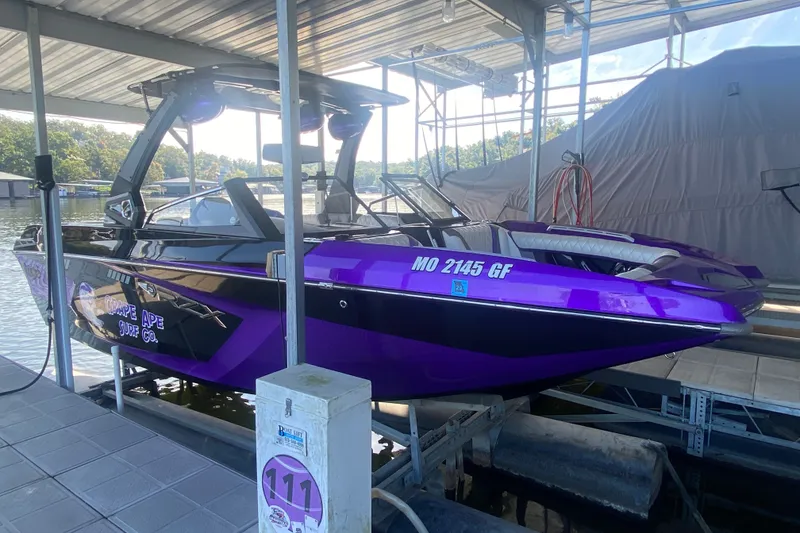 Slide: The Image of 2017 Tigé RZX3 boat in vibrant purple, docked under a covered marina. - 29