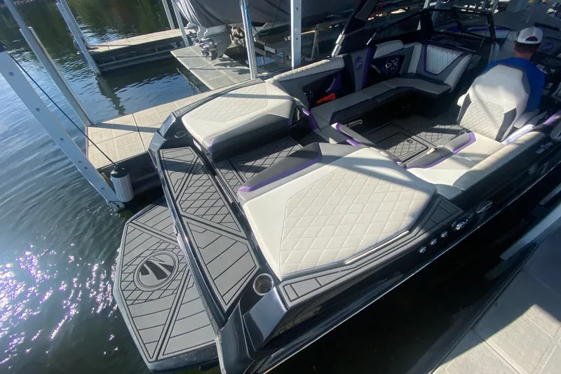 Slide: The Image of 2017 Tigé RZX3 boat with luxurious seating and sleek design at a dock. - 21