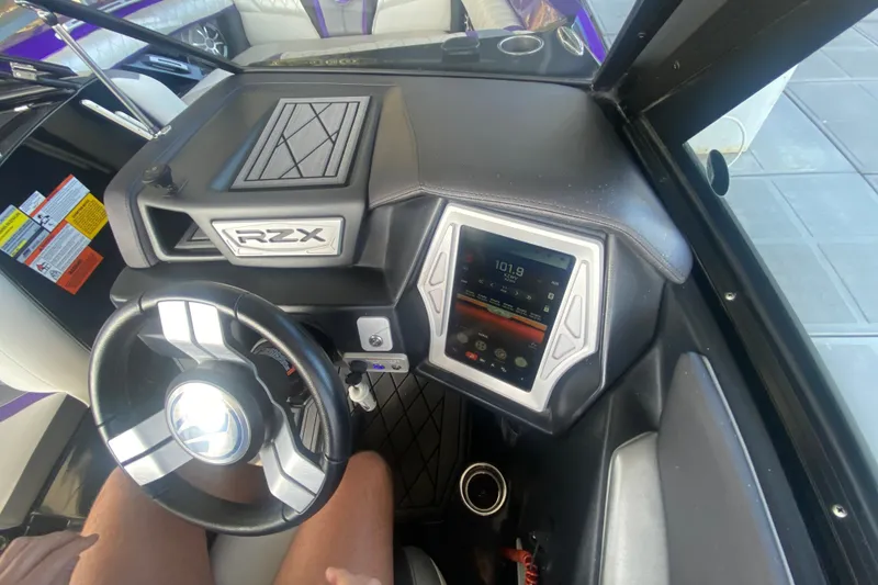 Slide: The Image of 2017 Tigé RZX3 boat dashboard with touchscreen display and steering wheel. - 23