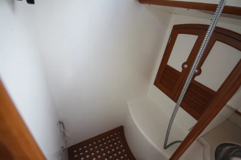 Slide: The Image of Small shower area in 2001 Outbound 44/46 yacht with wooden accents and hose. - 17