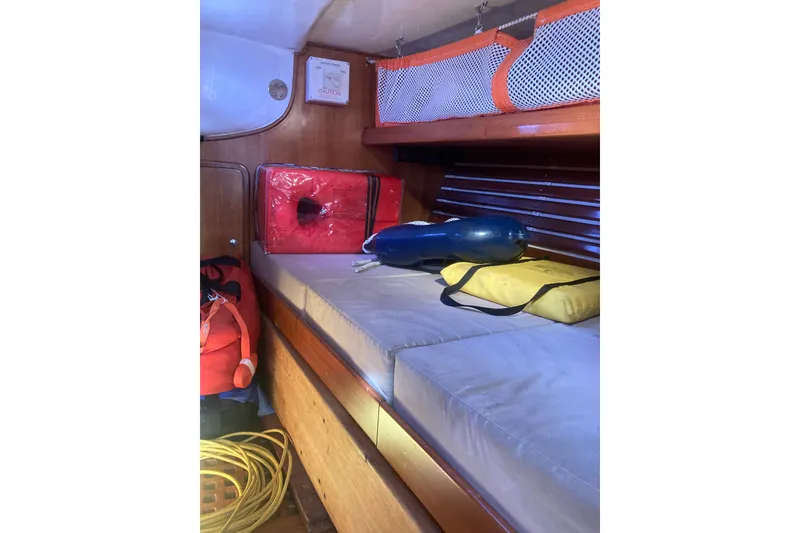 Slide: The Image of Interior of 2001 Outbound 44/46 sailboat with storage, cushions, and safety equipment. - 28