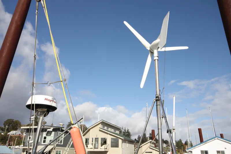 Slide: The Image of Wind turbine and radar on Outbound 44/46 sailboat, 2001 model, docked near houses. - 53