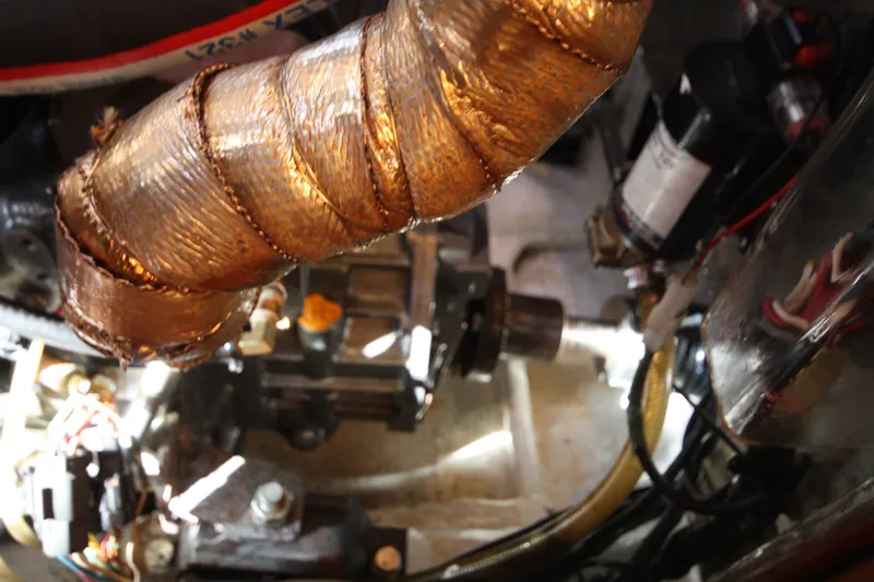 Slide: The Image of Engine compartment of a 2001 Outbound 44/46 yacht, featuring wrapped components and wiring. - 38