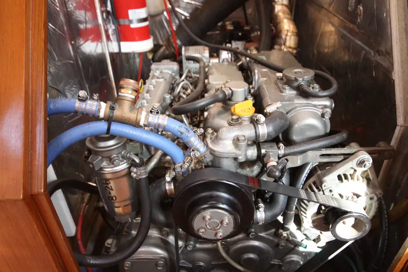 Slide: The Image of Engine compartment of a 2001 Outbound 44/46 sailboat, featuring hoses and mechanical components. - 36