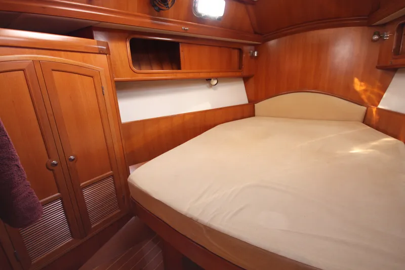 Slide: The Image of Cozy cabin interior of 2001 Outbound 44/46 yacht with wooden furnishings and bed. - 20