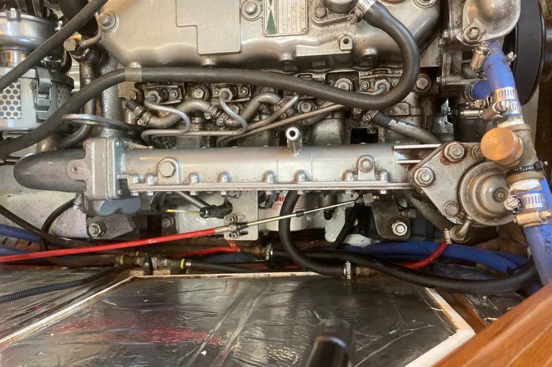 Slide: The Image of Engine compartment of a 2001 Outbound 44/46 sailboat, showcasing mechanical components and hoses. - 35