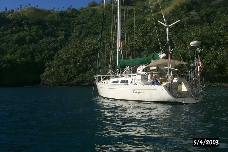 Slide: The Image of Sailboat "Sequoia" anchored near lush green hills, Outbound 44/46, 2001 model. - 58