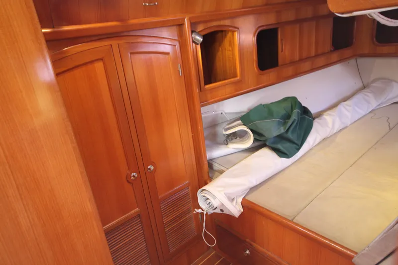Slide: The Image of Wooden interior of 2001 Outbound 44/46 sailboat with storage and rolled sail. - 26