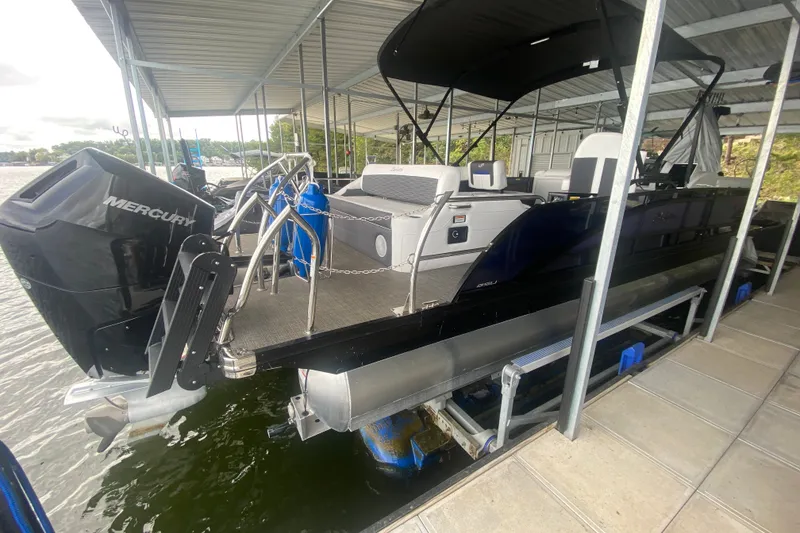 Slide: The Image of 2024 Barletta Corsa 25U pontoon boat docked, featuring a Mercury outboard motor. - 13