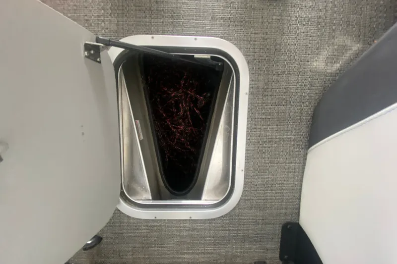 Slide: The Image of Open storage compartment on 2024 Barletta Corsa 25U boat, revealing interior details. - 27
