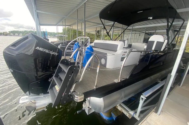 Slide: The Image of 2024 Barletta Corsa 25U pontoon boat docked with Mercury outboard engine. - 12