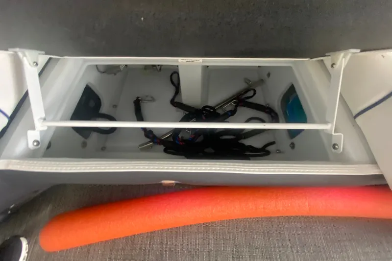 Slide: The Image of Storage compartment of 2024 Barletta Corsa 25U boat with equipment and orange float. - 24