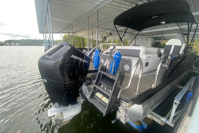 Slide: The Image of 2024 Barletta Corsa 25U pontoon boat with Mercury outboard engine docked in marina. - 31