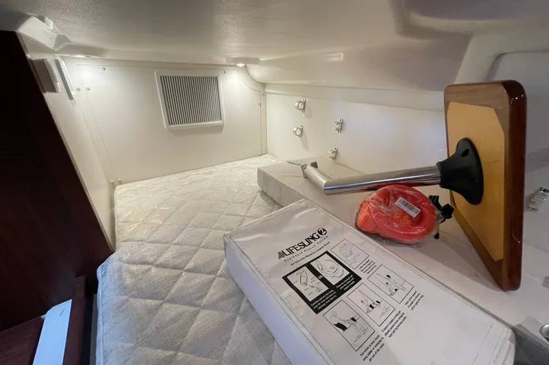 Slide: The Image of 2022 Pursuit OS 355 Offshore cabin interior with mattress and safety equipment. - 40