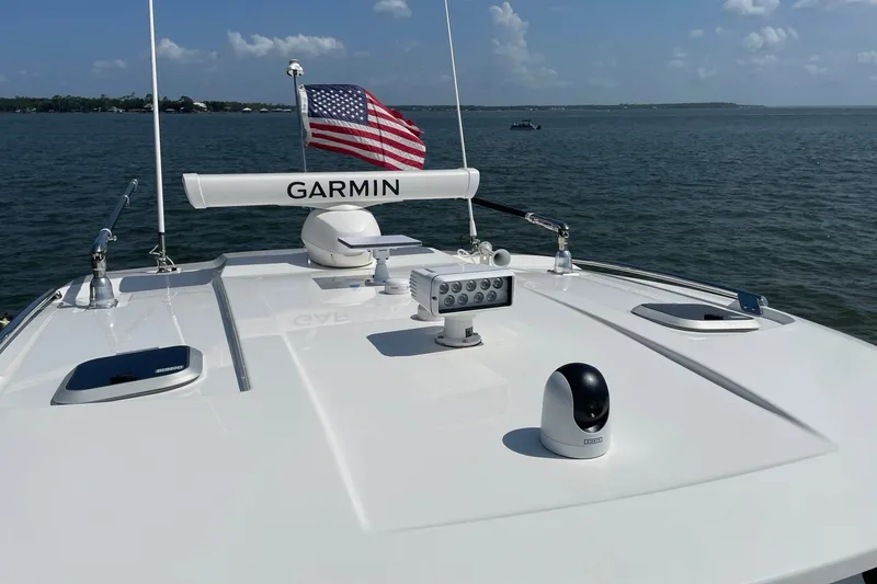 Slide: The Image of 2022 Pursuit OS 355 Offshore boat with Garmin equipment and American flag on open water. - 7