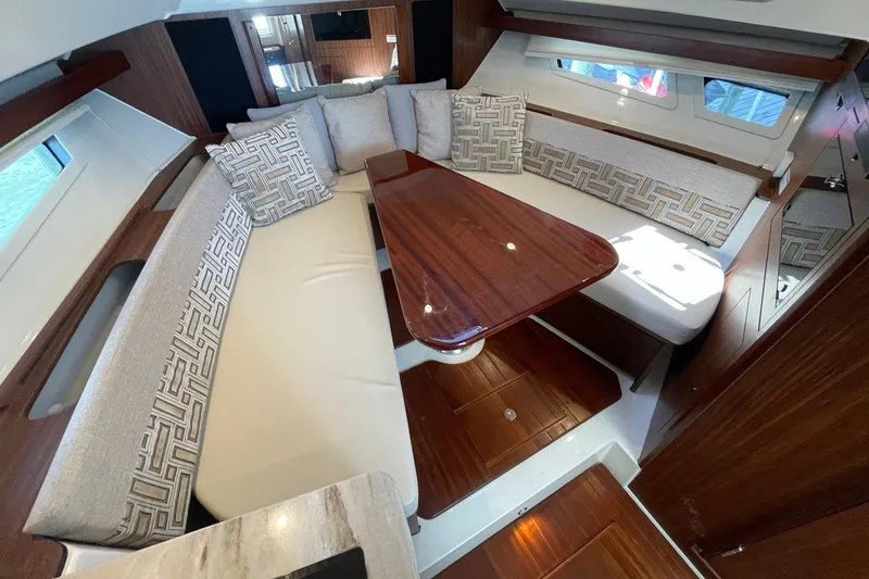 Slide: The Image of Luxurious interior of 2022 Pursuit OS 355 Offshore yacht with elegant seating and wooden table. - 35