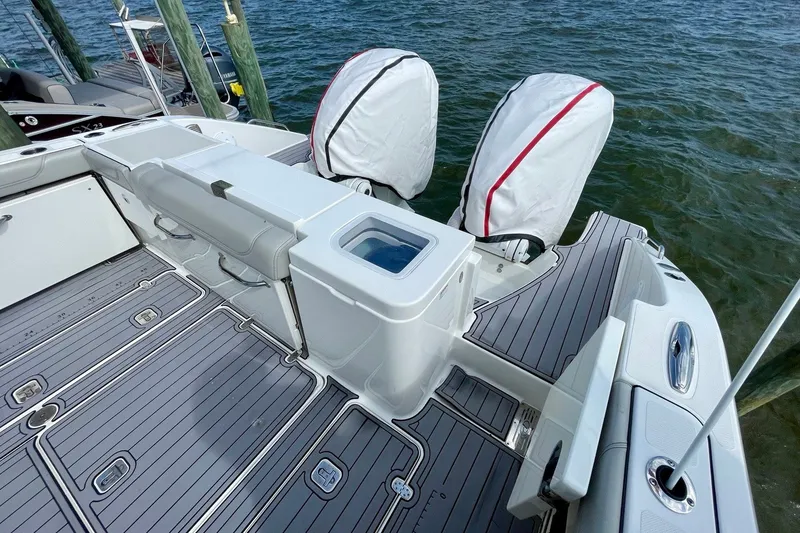 Slide: The Image of 2022 Pursuit OS 355 Offshore boat deck with covered engines and sleek design. - 13