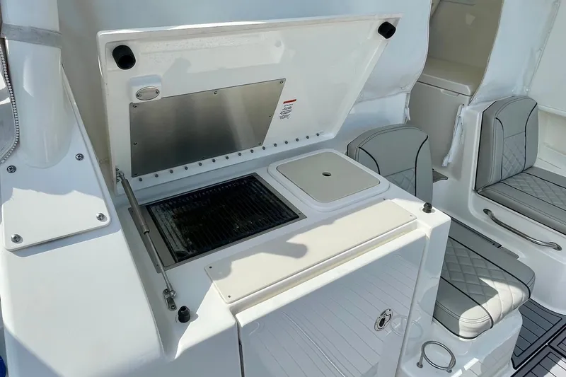 Slide: The Image of 2022 Pursuit OS 355 Offshore boat interior with grill and seating area. - 18